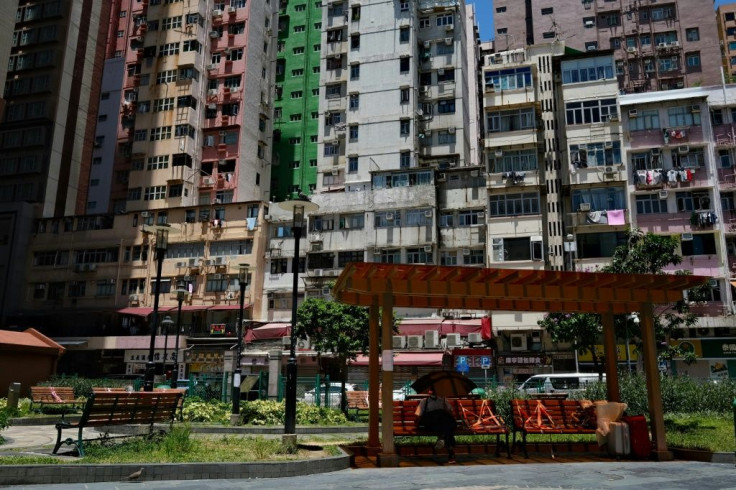 A man sits on a park bench partially cordoned off to enforce social distancing in Hong Kong