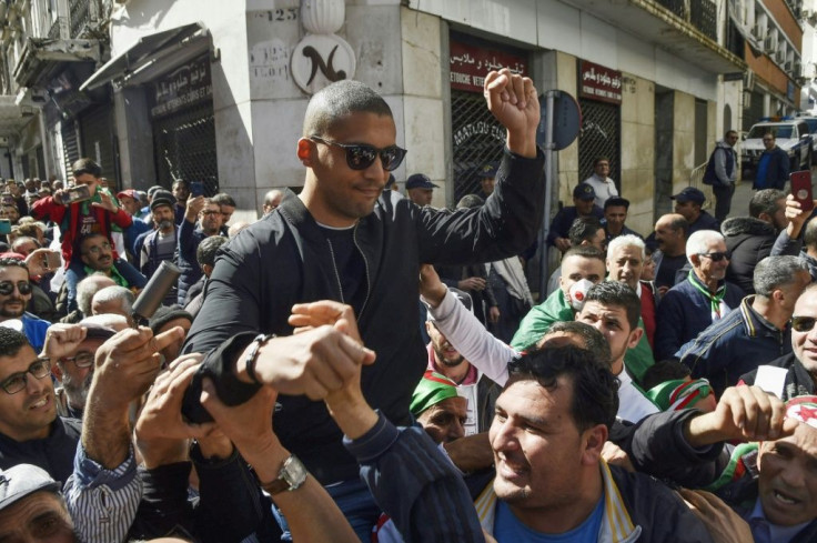 Algerian protesters carry journalist Khaled Drareni on their shoulders on March 6, 2020, the day before he was arrested while covering an anti-government protest, accused of "inciting an unarmed gathering"