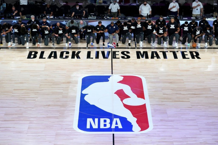 Members of the Utah Jazz and New Orleans Pelicans kneel during the US national anthem as the NBA restarts in Orlando