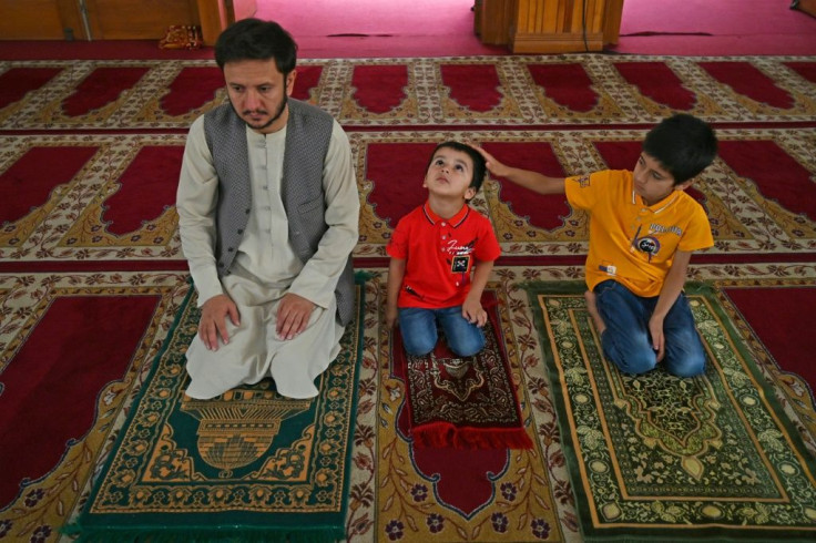 Hundreds of Afghans went to mosques across Kabul to mark the festival of Eid al-Adha, as a ceasefire between Taliban and government forces began