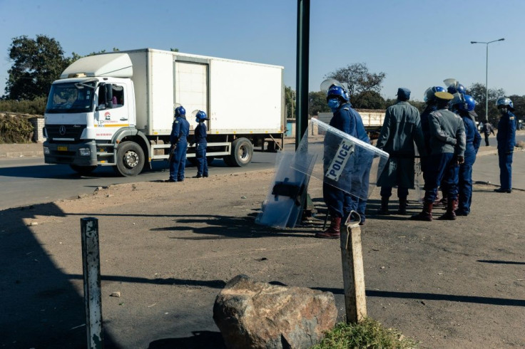 Police ask for travel documents at a road block in Mbare, a township in the suburbs of Harare