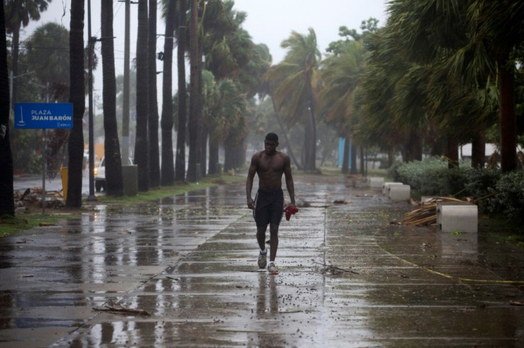 A man walks under pouring rain during Isaias storm in Santo Domingo, on July 30, 2020