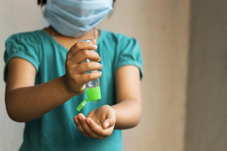 kids wearing mask using sanitizer