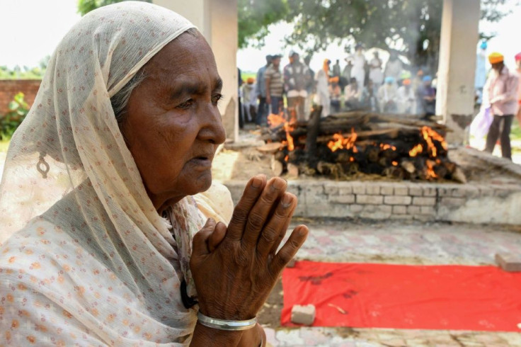 Veer Kaur, mother of a victim of toxic bootleg alcohol, stands next to her son's burning pyre in the village of Muchhal some 30 kilometres from Amritsar on August 1, 2020