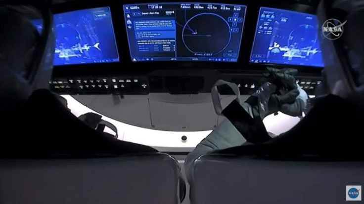 This NASA video frame grab image shows SpaceX's Crew Dragon spacecraft with NASA astronauts Douglas Hurley and Robert Behnken watching an infrared view of the International Space Station on their screens after undocking from it