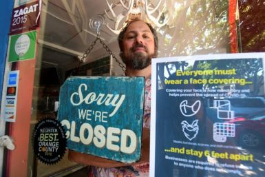 Gabriel Gordon stands behind the glass entrance door to his restaurant Beachwood BBQ, in Seal Beach, Californian, which he has been forced to permanently shut down because of the coronavirus pandemic.