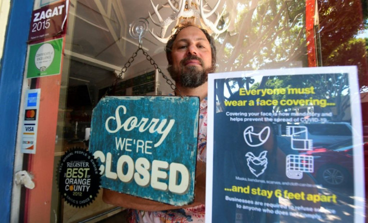 Gabriel Gordon stands behind the glass entrance door to his restaurant Beachwood BBQ, in Seal Beach, Californian, which he has been forced to permanently shut down because of the coronavirus pandemic.