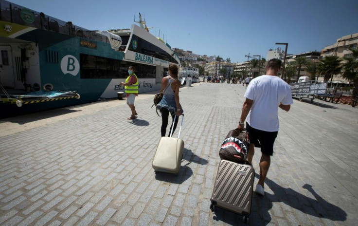 Tourists arrive by ferry at Ibiza's harbour