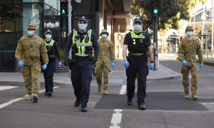 A group of police and soldiers patrol the Docklands area of Melbourne after the announcement of new restrictions to curb the spread of the coronavirus