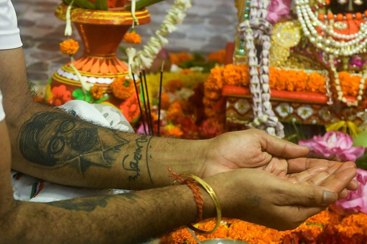 A fan with a tattoo of Amitabh Bachchan on his arm takes part in a ceremony praying for the Bollywood star's recovery from coronavirus in Kolkata