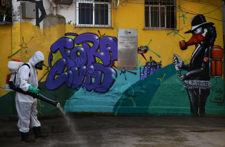 A volunteer disinfects an area inside Santa Marta Favela, in Rio de Janeiro, Brazil