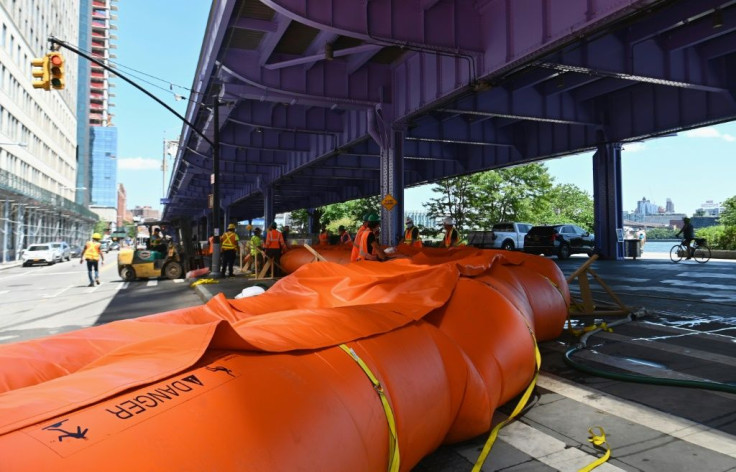 Workers set up temporary plastic flood barriers and sandbags known as 'Tiger Dams' in lower Manhattan to protect the area from flooding as tropical storm Isaias approaches New York City on August 3, 2020