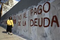 A woman passes by a wall reading "No to the Debt Payment" in Buenos Aires, on August 3, 2020 -- the day before a deal was reached on restructuring of $66 billion of debt