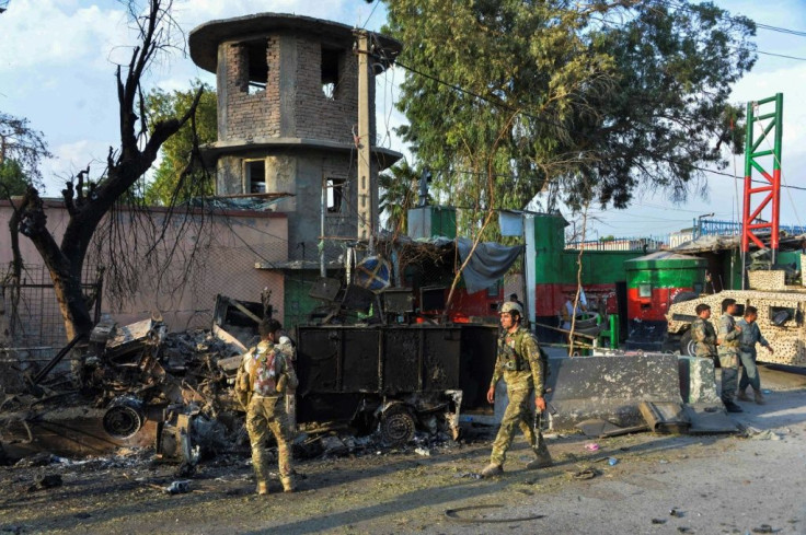 Afghan soldiers walk past the prison in Jalalabad after regaining control following the raid