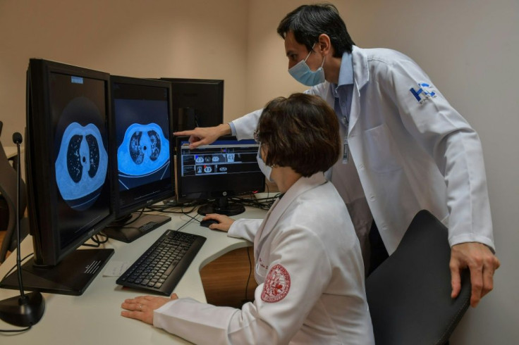 Claudia Leite (L) and Marcio Sawamura of the University of Sao Paulo Clinical Hospital look at tomography images of lungs