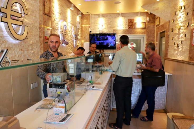 Iraqis wait at a money exchange office in Sulaimaniyah