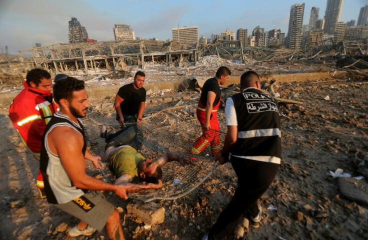 Lebanese firefighters evacuate a wounded man across the rubble of buildings flattened by the force of the monster blast in Beirut port