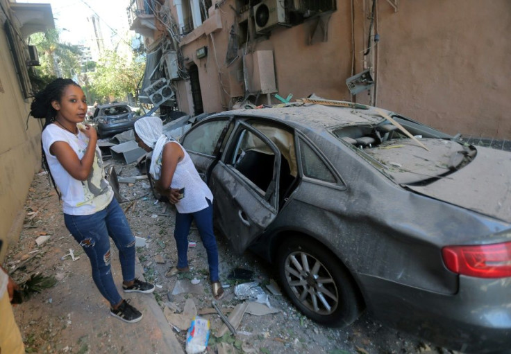 Migrant women walk through the rubble in one of Beirut's heavily damaged neighbourhoods