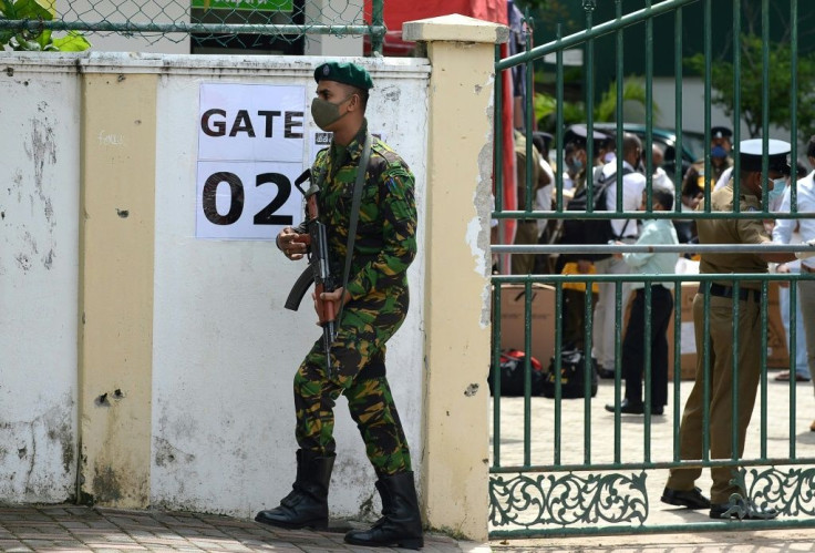 A Sri Lanka Special Task Force soldier stands guard as electoral officials collect ballot papers and boxes from a distribution centre in Colombo