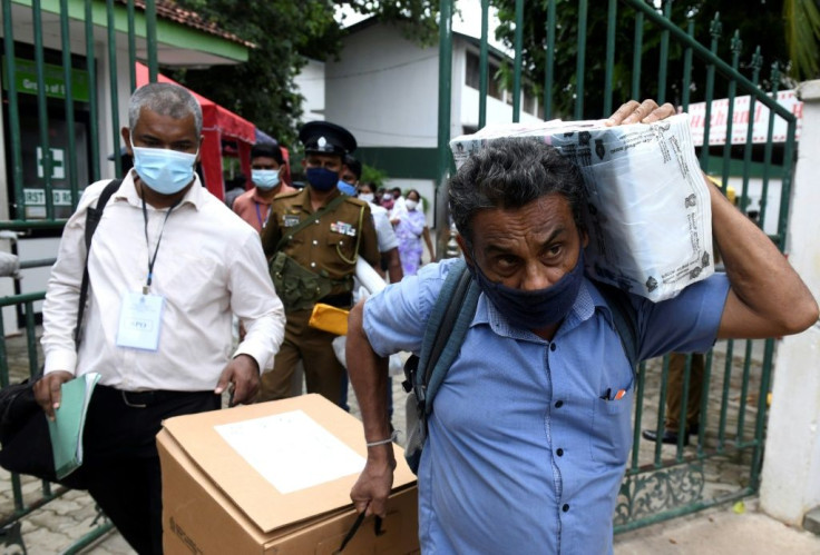 Officials collect ballot papers and boxes from a distribution centre in Colombo