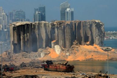 A picture taken on August 5, 2020 shows the damaged grain silo and a burnt boat at Beirut's harbour, a day after a powerful explosion tore through Lebanon's capital,when a huge depot of ammonium nitrate ignited at the city's main port