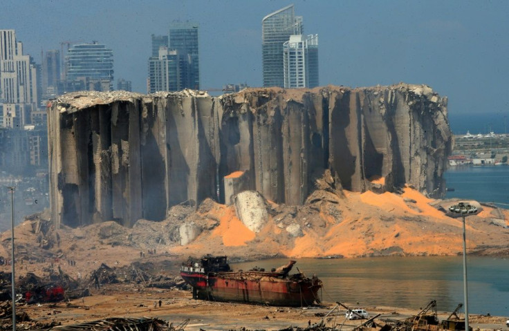 A picture taken on August 5, 2020 shows the damaged grain silo and a burnt boat at Beirut's harbour, a day after a powerful explosion tore through Lebanon's capital,when a huge depot of ammonium nitrate ignited at the city's main port