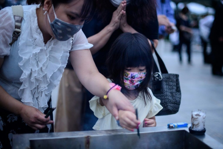 Visitors burn incense at the Hiroshima Peace Memorial Park to mark 75 years since the world's first atomic bomb attack