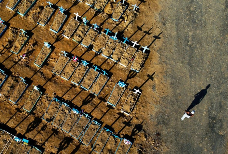 An aerial view showing a man walking past graves in the Nossa Senhora Aparecida cemetery in Manaus, Brazil in seen in June 2020