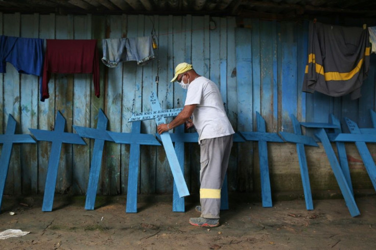 Cemetery worker Ulisses Xavier, 52, places homemade wooden crosses along a wall at his home in Manaus, the regional capital of Brazil's Amazonas state, and the city where some indigenous peoples have had to seek COVID-19 treatment