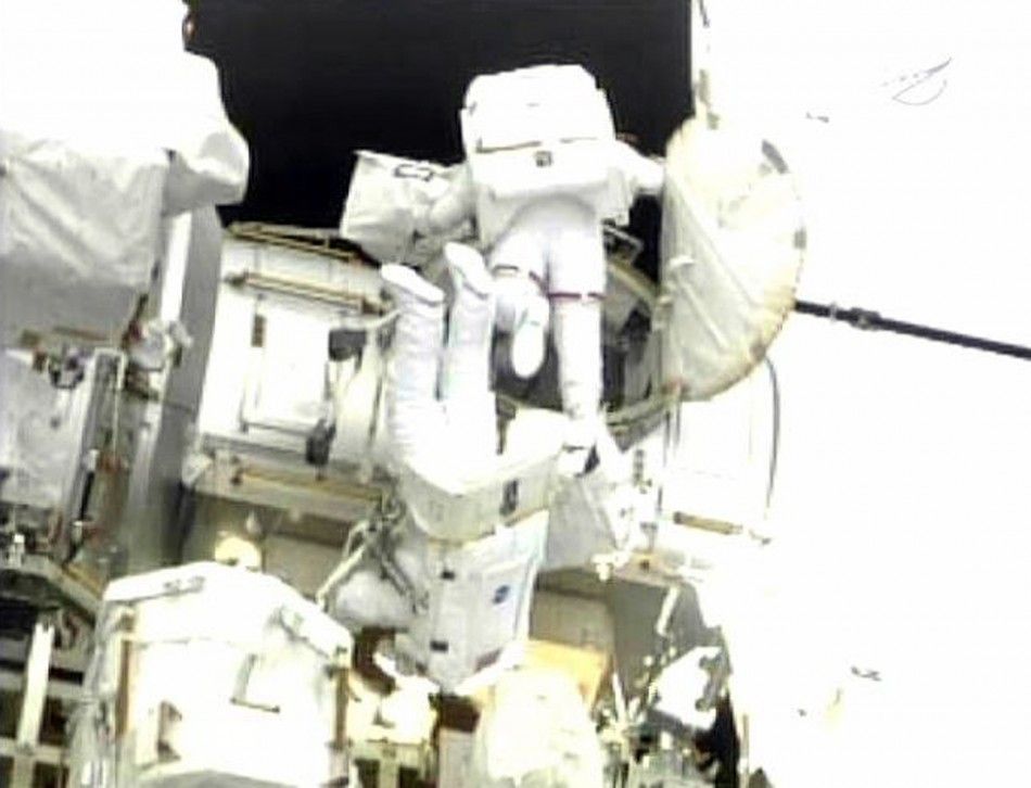 Space shuttle Endeavour astronauts Mike Fincke and Drew Feustel exit the Qwest airlock at the beginning of their spacewalk in this image from NASA TV.