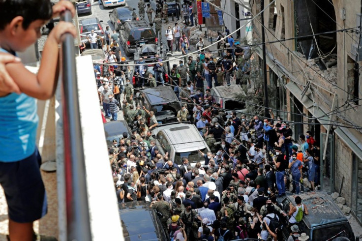 A Lebanese boy watches from a balcony as French President Emmanuel Macron visits the Gemmayzeh neighbourhood, which has suffered extensive damage