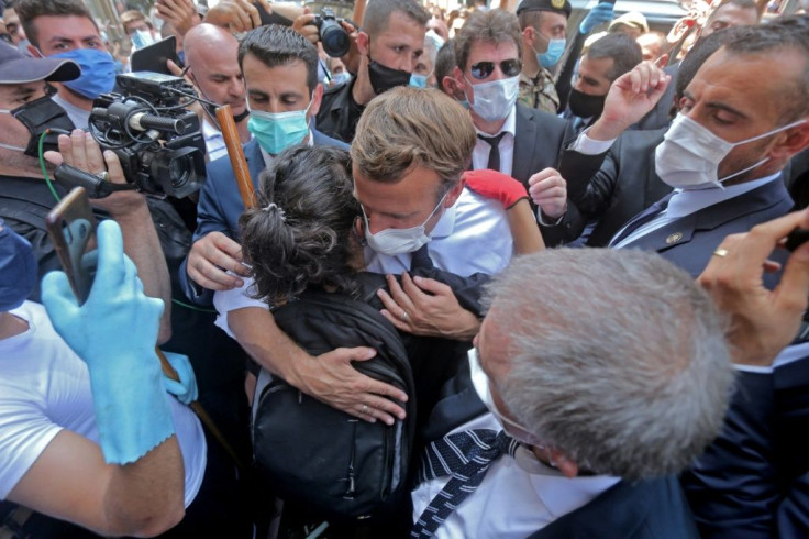 A Lebanese youth hugs Macron during a visit to the Beirut's badly-hit Gemmayzeh neighborhood