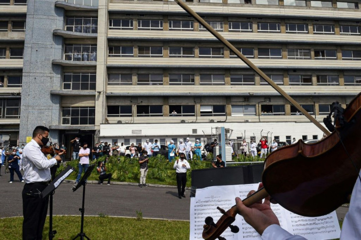 Musicians from Medellin's Philarmonic Orchestra in Colombia play in front of a hospital