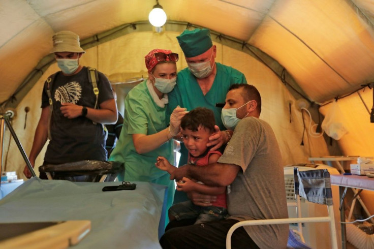 Medics treat a patient at a Russian field hospital set up in Beirut's largest sports stadium