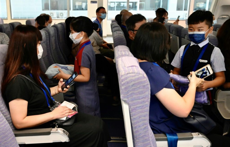 Children act as flight attendants in a mock cabin before a sightseeing 'flight to nowhere' later in the day