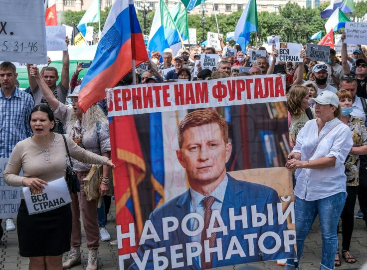 Protestors in the Russian Far East city of Khabarovsk  carry a banner reading "Return Furgal for us", during an unauthorised rally Saturday in support of Sergei Furgal