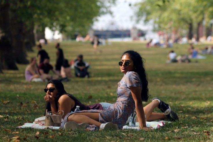 People relax in the hot weather in Green Park as the heatwave continues in London