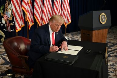 President Donald Trump signs executive actions extending coronavirus economic relief during a news conference at his golf club in  Bedminster, New Jersey, on August 8, 2020