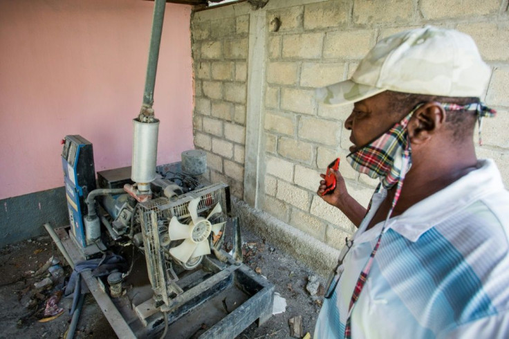 Lucien Jean-Francois, principal of the public Tabarre school in Port-au-Prince, shows the school's generator; a part was stolen, so water can only be pumped by hand at a time when frequent washing is being urged to stem the coronavirus's spread
