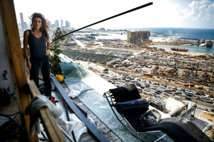 Lebanese architect and designer Karina Sukkar stands on the balcony of her damaged apartment overlooking the ravaged port of Lebanon's capital Beirut