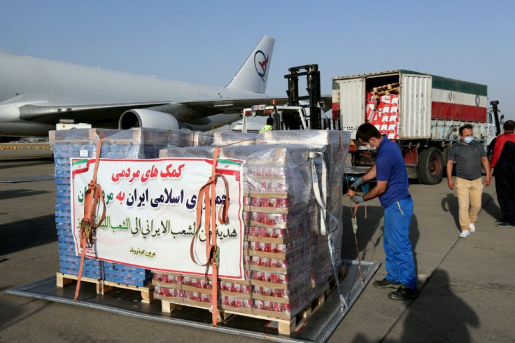 Iranian Red Crescent workers load a plane with aid to the Lebanese people on the tarmac of Mehrabad airport in the capital Tehran