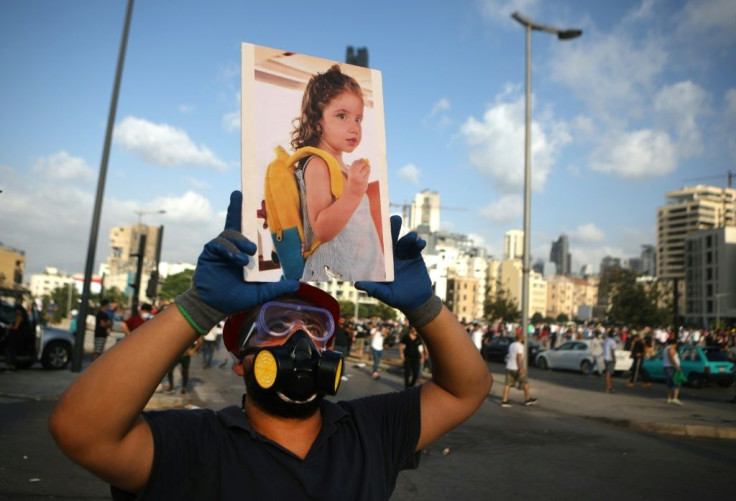 A Lebanese protester carries a photo of three-year-old Alexandra, who was fatally injured in the port explosion