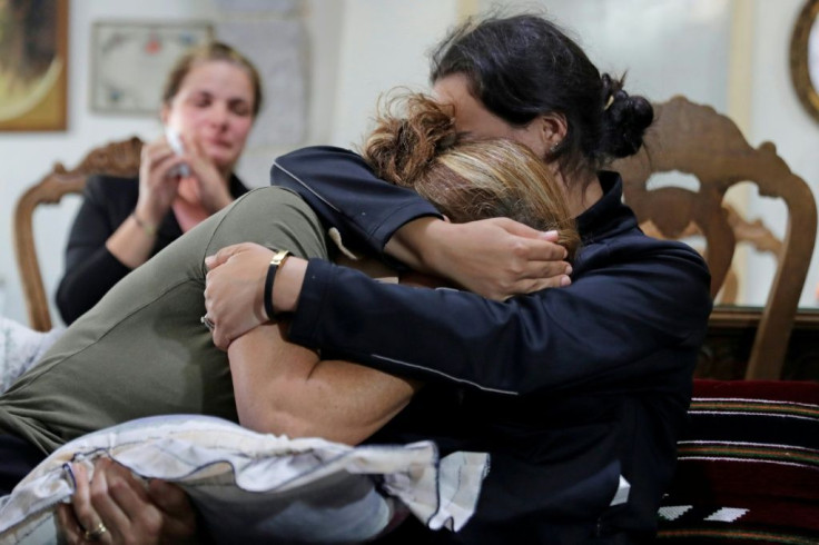 (L to R) Rita Hitti (mother of 27-year-old missing fireman Najib) and her daughter Carlyn (wife of 37-year-old missing fireman Charbel Karam) cry as they comfort each other at their home in the mountain town of Qartaba, north of the Lebanese capital