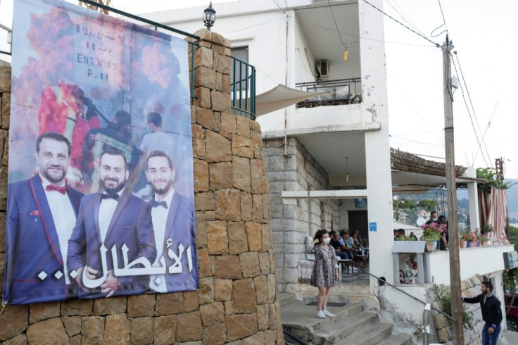 A banner bearing the portraits of three related missing firefighters who left together in one firetruck to douse a port fire believed to have sparked the August 4 massive blast in Beirut, near the Hitti family's house