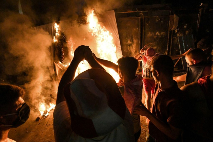 Lebanese protesters light a fire during clashes with security forces in the vicinity of the parliament building in the centre of Beirut