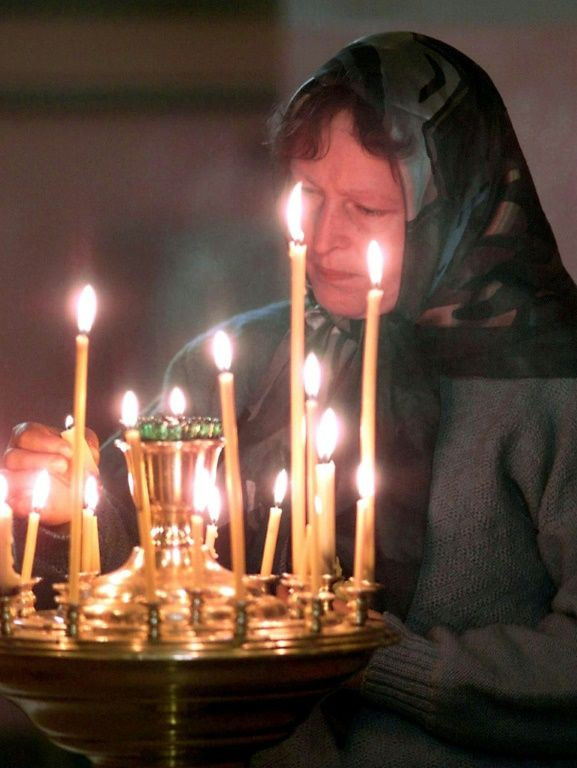 On August 17, 2000, a woman lights a candle in a church in the city of Murmansk, northwestern Russia, in memory of the Kursk crew