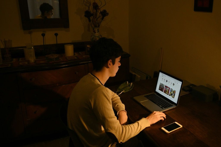 Argentine Francisco Avalos poses at his home while checking a delivery website to order a snack  for his girlfriend Guadalupe,  in Bernal, outside Buenos Aires, Argentina, on August 6, 2020, amid the COVID-19 pandemic