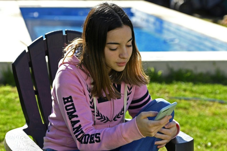 Argentine high school student Jazmin Islas uses her cell phone at her home's yard in La Plata, Buenos Aires, Argentina, on July 28, 2020