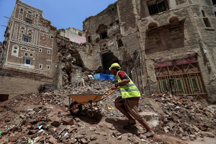 Yemeni labourers remove rubble ahead of restoration works on the site of a collapsed UNESCO-listed building following heavy rains in the Old City of the Yemeni capital Sanaa