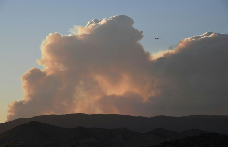 A plane flies past smoke from the Lake Fire in the Angeles National Forest